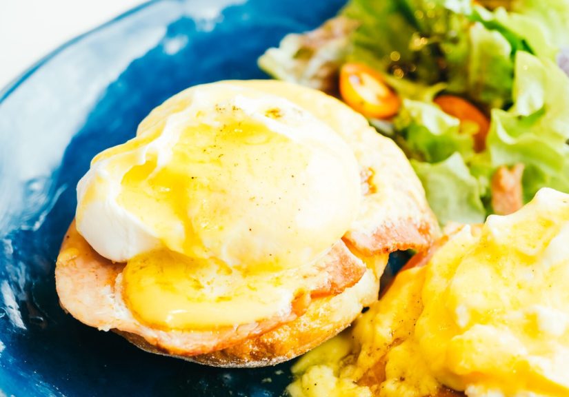 Eggs benedict with ham and sauce on top in plate - Color Filter Processing